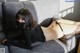 A woman laying on a couch wearing a black mask.