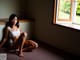 A woman sitting on the floor in front of a window.