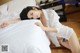 A woman laying on a bed in a white shirt and panties.