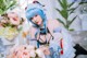 A woman with blue hair sitting next to a bunch of flowers.