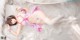 A woman laying on a bed in a pink and white lingerie.